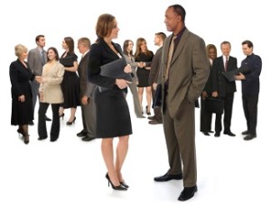 Group of corporate business people networking on a white background with a young man and woman in the foreground