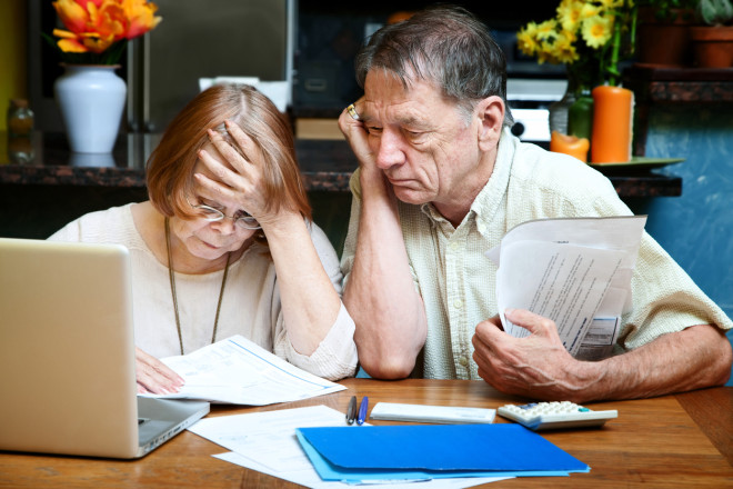 Senior couple at home with many bills dying with debt