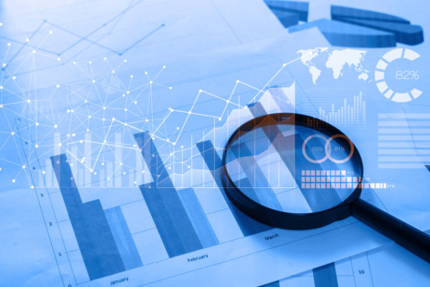 Magnifying glass and documents with analytics data lying on tabl skip tracing