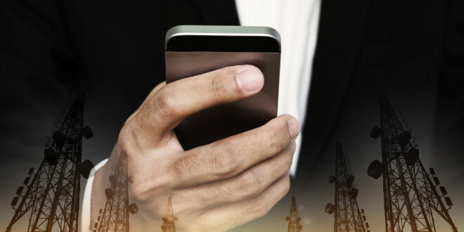 Businessman using mobile phone with multi exposure Telecommunication towers telecommunications debt