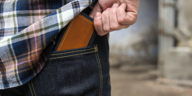 Confident man posing in selvedge  jeans credit card debt