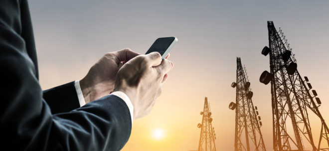 Businessman using mobile phone with multi exposure Telecommunication towers utility industry credit and collections