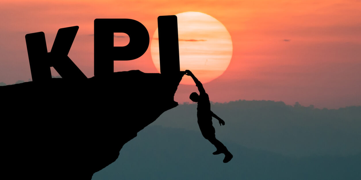 Young businessman climbing the mountain to achieve KPI with sunset background. (to reach key performance indicator) revenue cycle management