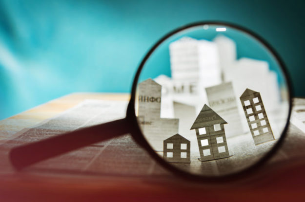 Paper house under a magnifying lens credit managers