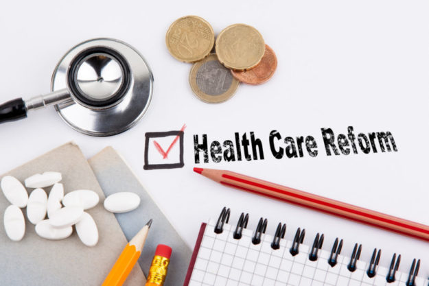 health care reform. Questionnaire with red cross on the white paper value based healthcare