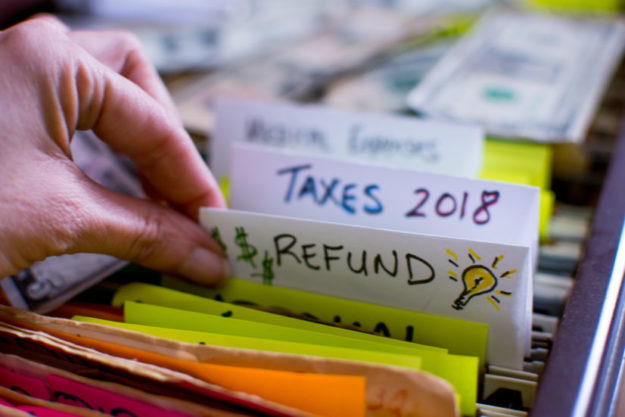 Woman pulling out file on Tax season 2018 Tax refund tax season strategy