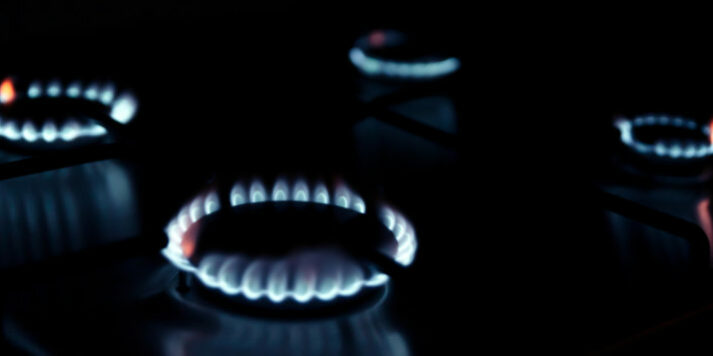 Gas kitchen stove cook with blue flames burning