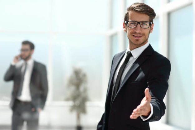 successful businessman reaching out for a handshake client relations