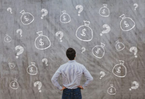 Man in front of wall money bags question marks