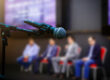 Microphone in front businesspeople blurred in conference meeting room