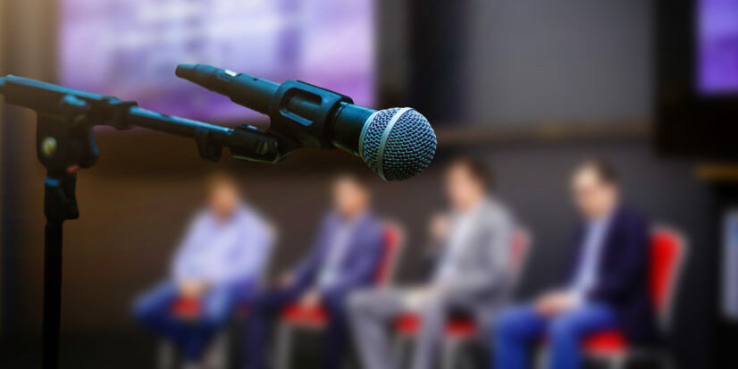Microphone in front businesspeople blurred in conference meeting room