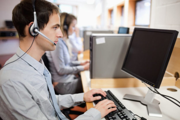 Serious operator using a computer debt collection agency cubicles