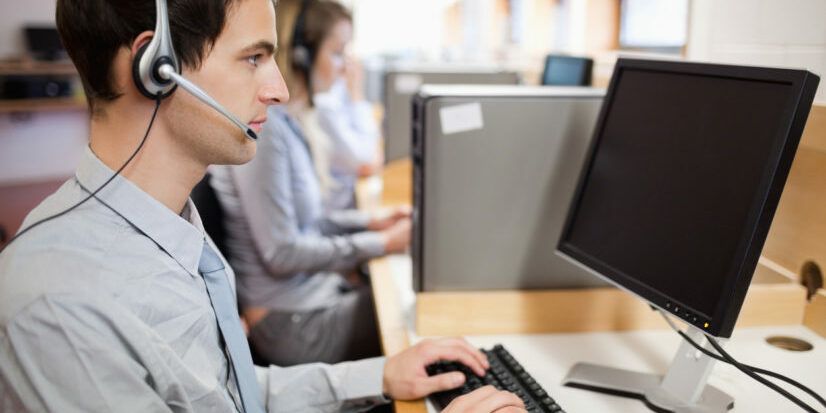 Serious operator using a computer debt collection agency cubicles
