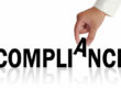 Hand spelling out the word compliance management system