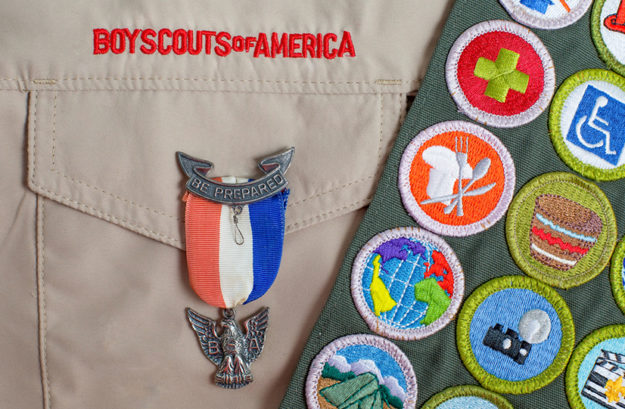 Eagle pin and merit badge sash on boy scout uniform be prepared