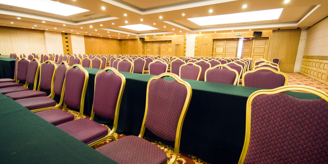 Rows of chairs with purple fabric seats in a conference room
