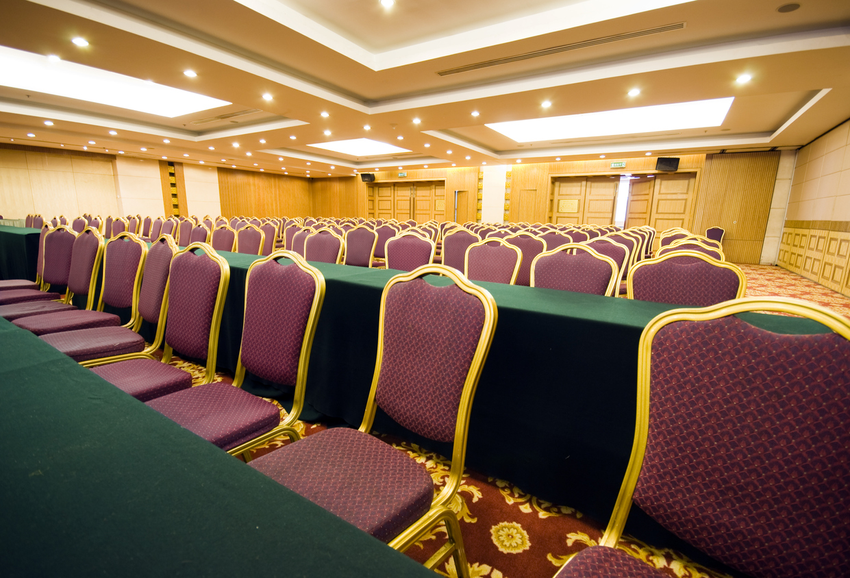 Rows of chairs with purple fabric seats in a conference room